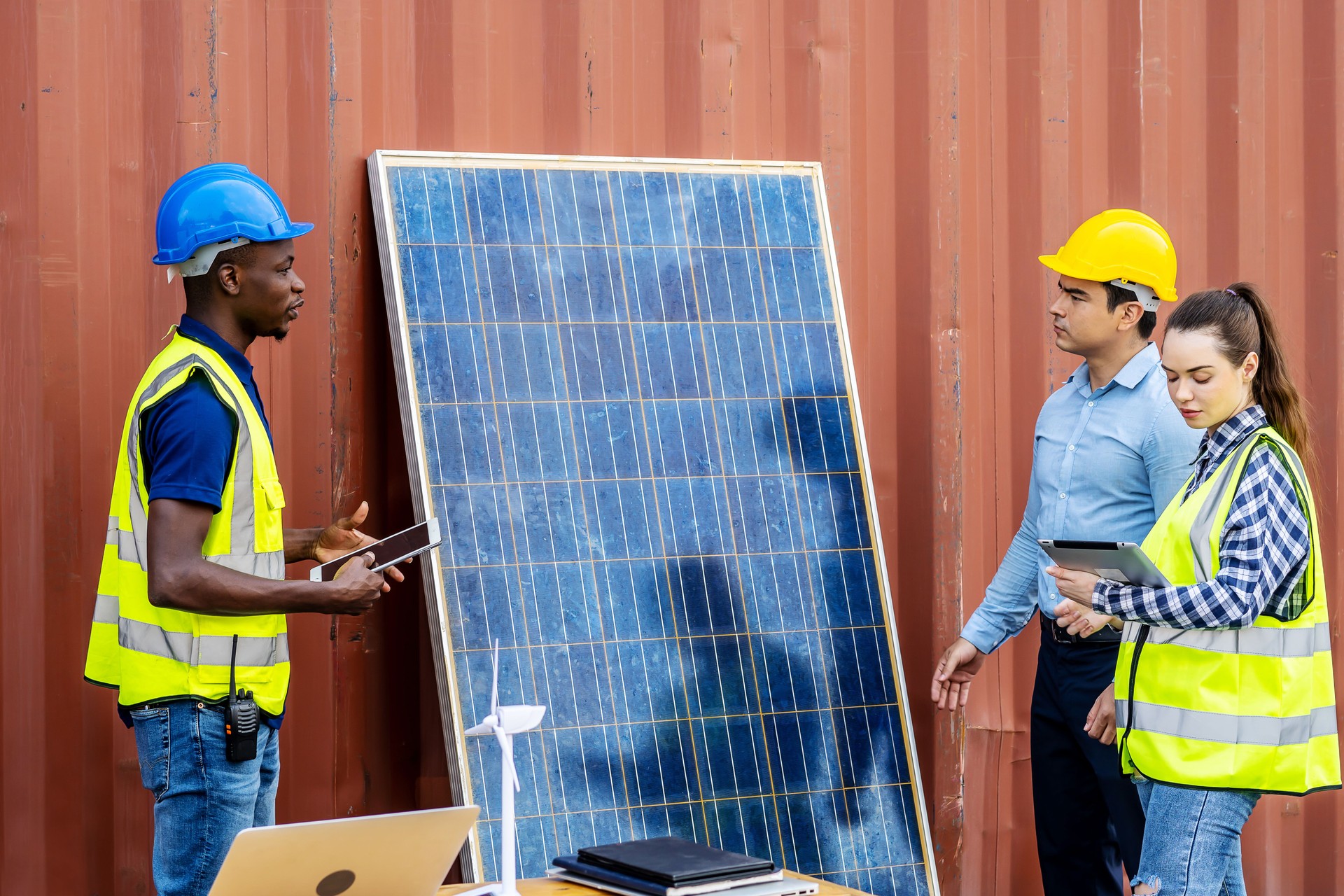 Two male energy engineers with his woman colleague team discussing new project about to invest in install solar cells outside building or industrial factory